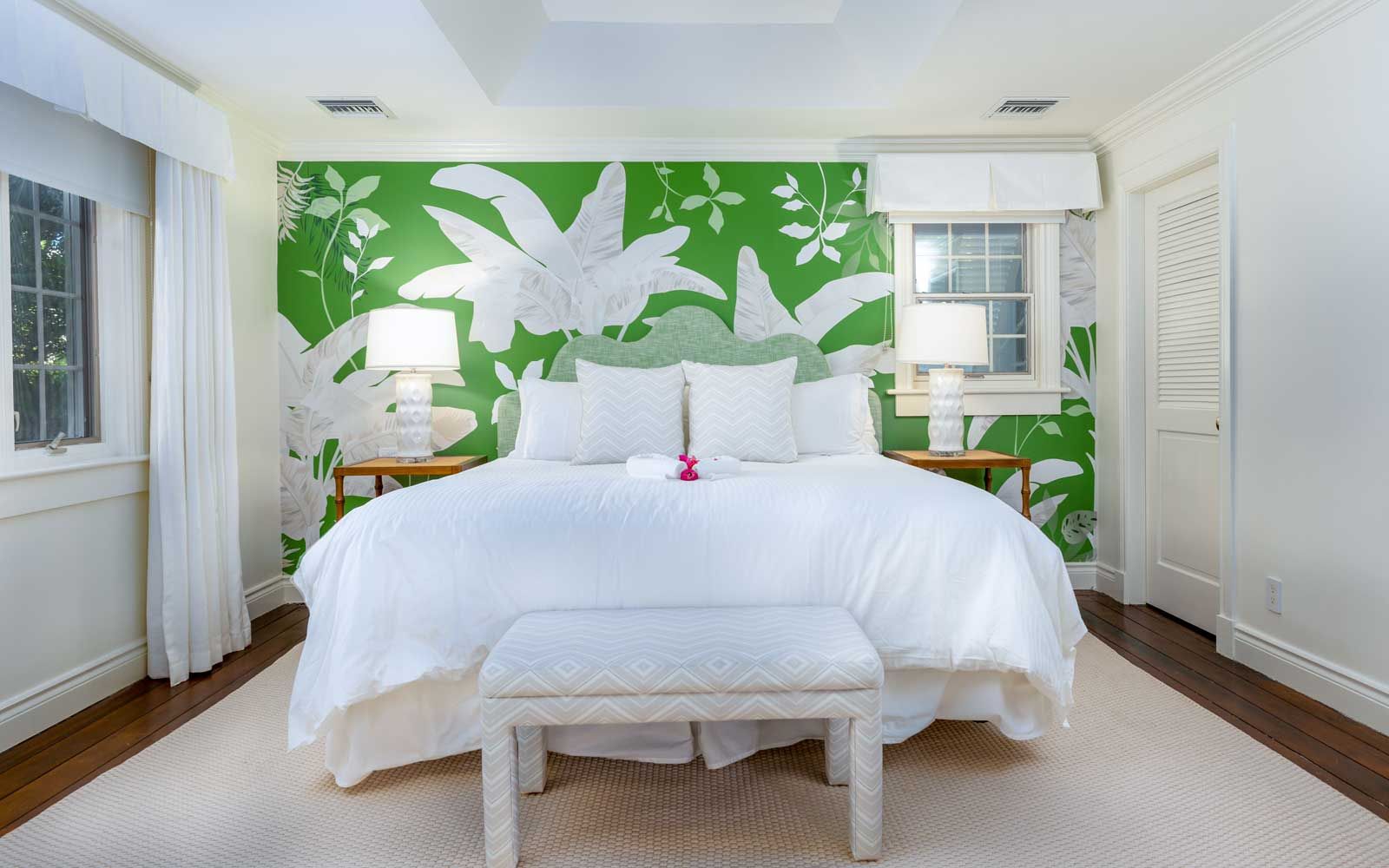 Ein Gästezimmer im Boutique-Resort Point Grace auf den Turks- und Caicosinseln mit einer grün-weißen Wand mit tropischem Print