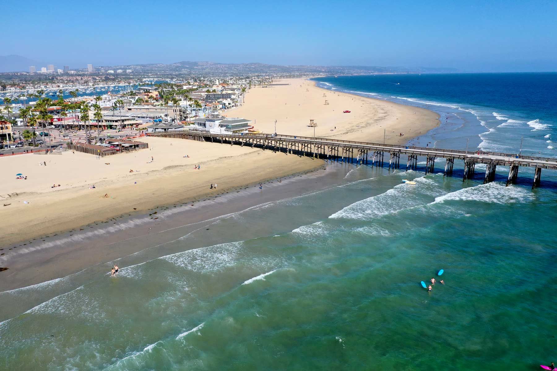 Eine Luftaufnahme einiger Surfer und Strandgänger, die trotz der harten Schließung von Gouverneur Gavin Newsoms, die am 4. Mai 2020 in Newport Beach, CA, noch immer besteht, einen schönen Tag am Strand genießen.