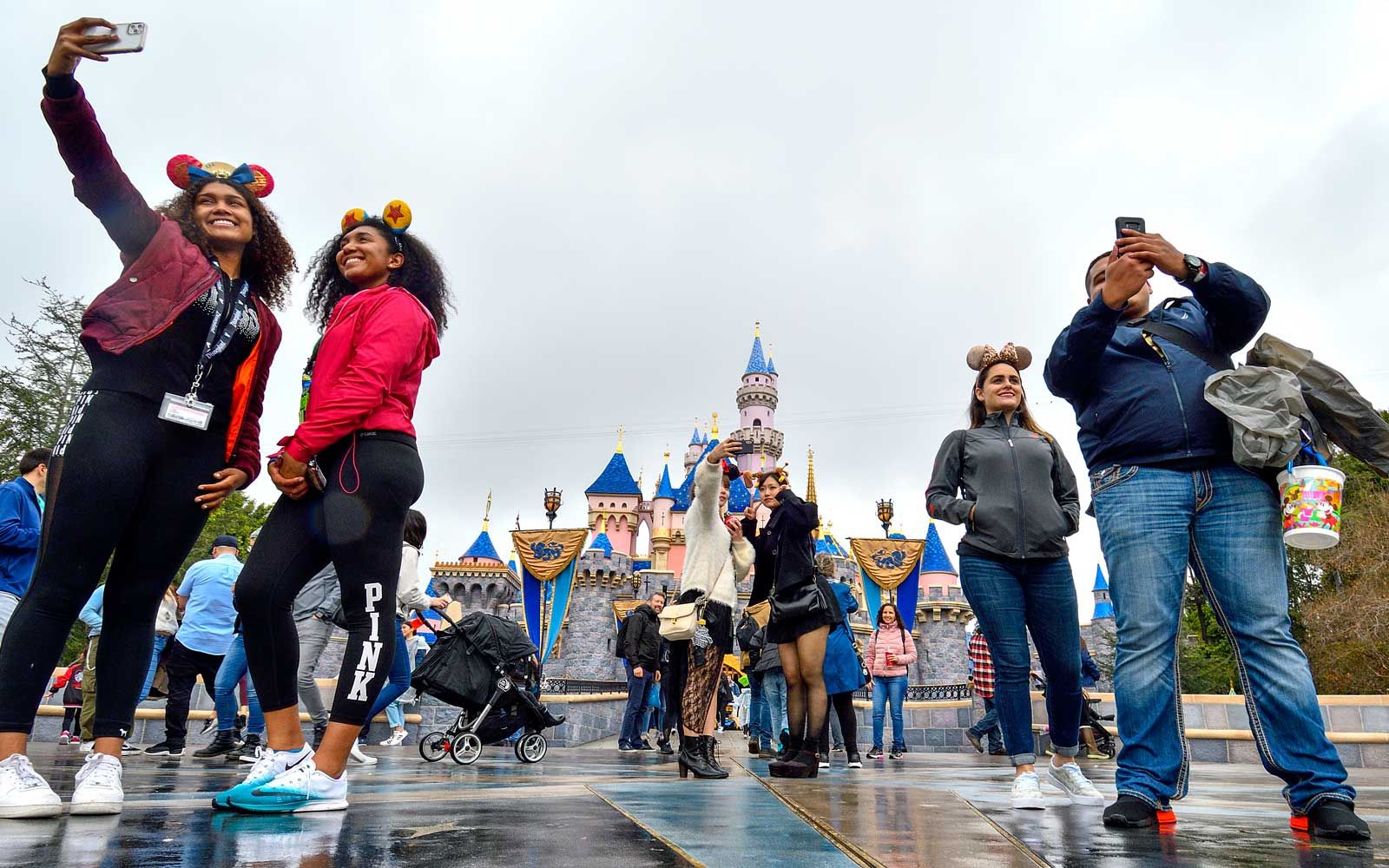 Besucher machen am letzten Tag vor der Schließung von Disneyland wegen des Coronavirus vor dem Dornröschenschloss Selfies