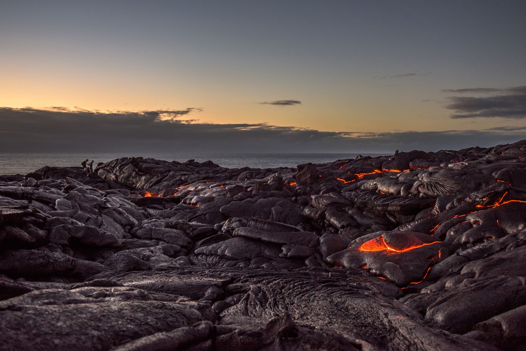 Camminendu nantu à un campu di lava nantu à a costa di u Pacificu vicinu à Kalapana in a Grande Isula di Hawaii à l'alba.