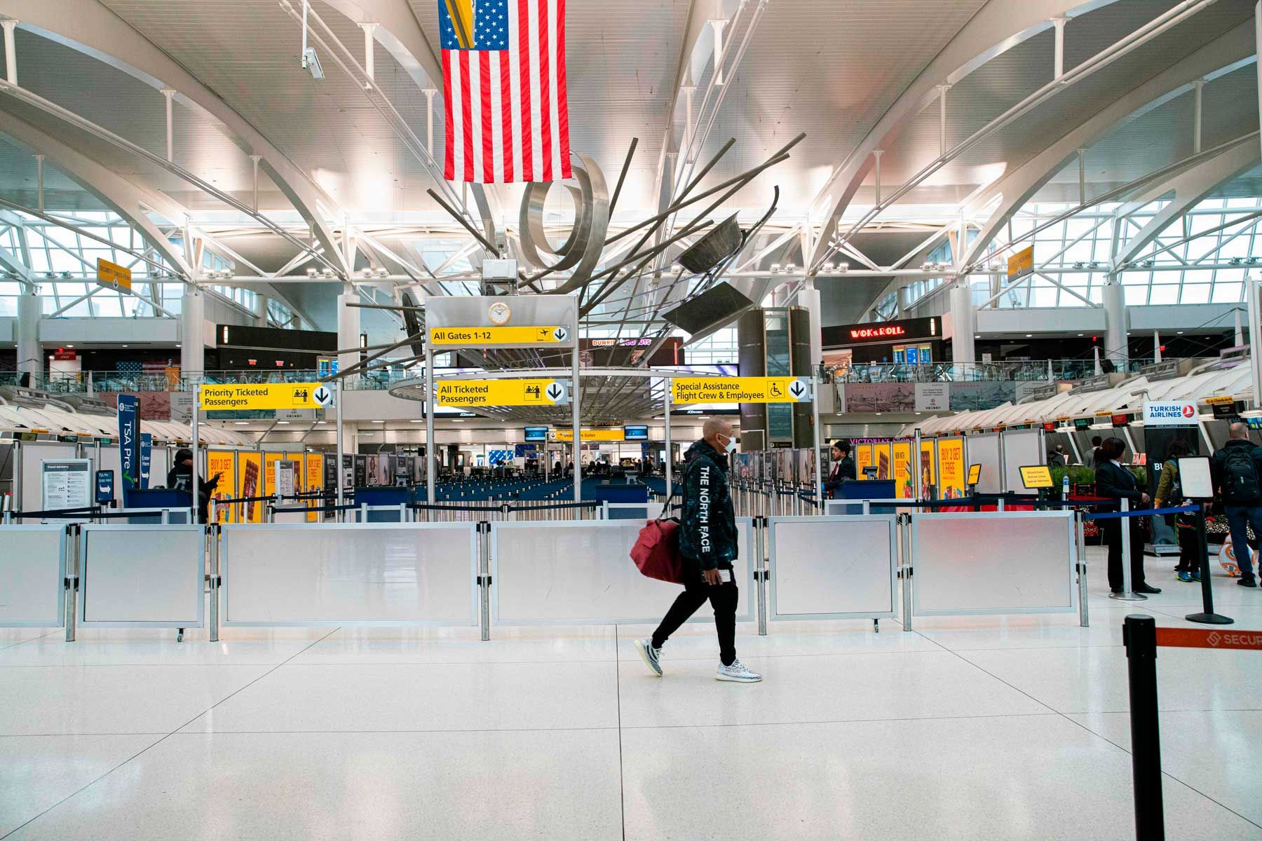 En mand går forbi tællere i Terminal 1-sektionen i John F. Kennedy International Airport den 12. marts 2020 i New York City