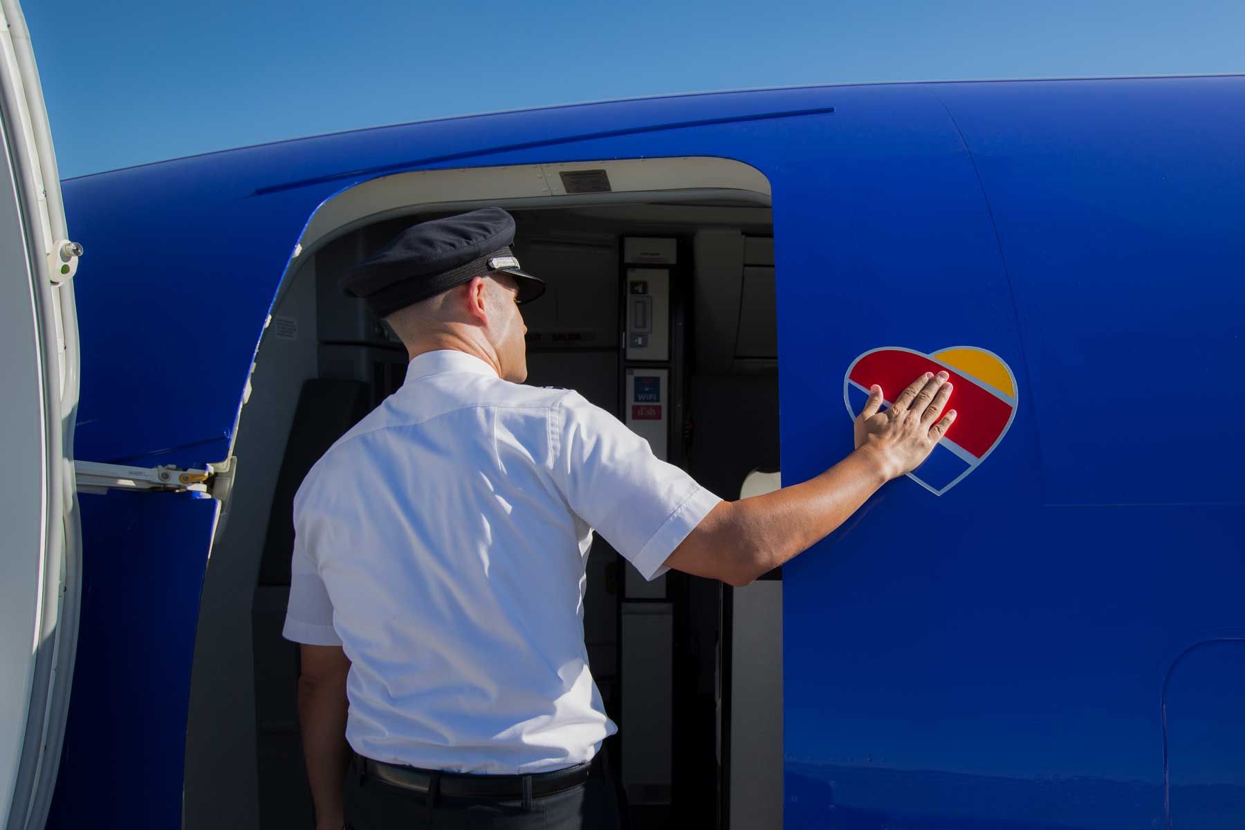 Pilot, der das Southwest Airlines-Logo berührt, als er das Flugzeug betritt