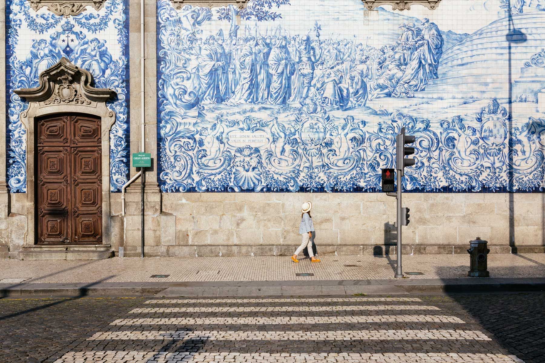 Donna chì cammina davanti à a chjesa Carmo in Porto, Portugallu